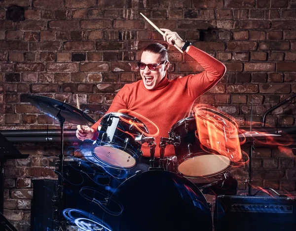 感情的にレンガの壁を背景にドラムのサングラスでスタイリッシュなミュージシャン — ストック写真