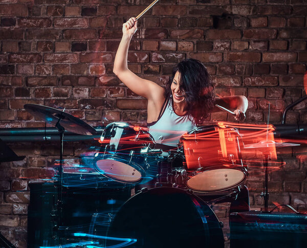 Young girl musician playing on drums and cymbals. Live music in a night club