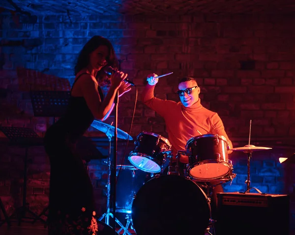 Jazzband prestaties. Aantal muzikanten - een drummer en een zangeres in een nachtclub. — Stockfoto