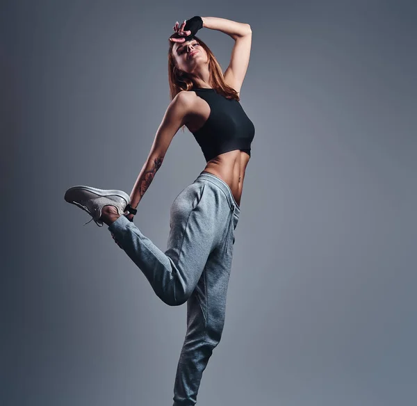 Retrato de cuerpo entero de una chica delgada usando ropa deportiva posando en un estudio . —  Fotos de Stock