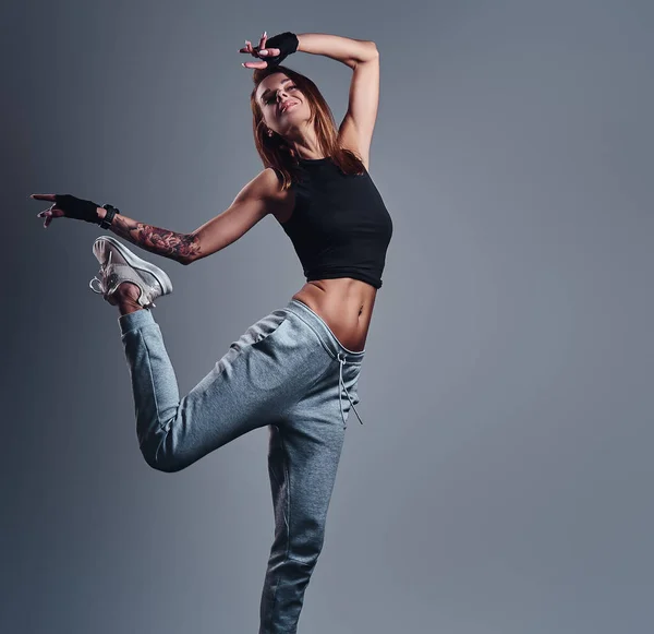 Full-length portrait of a slim fitness girl wearing sportswear posing in a studio. — Stock Photo, Image