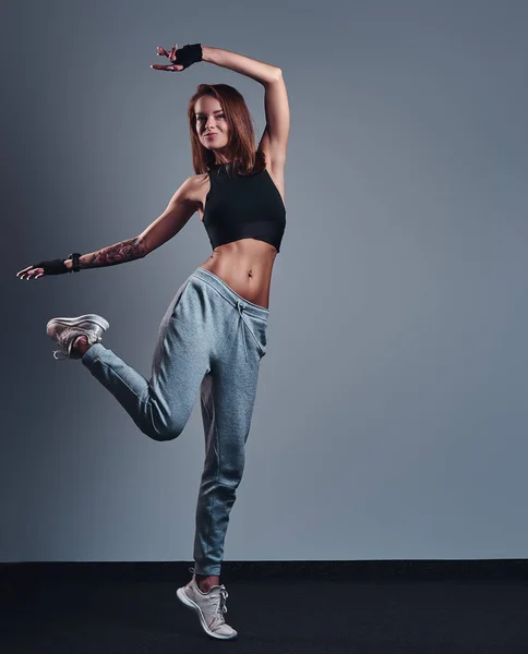 Celovečerní portrét tenký fitness dívka, která nosí sportovní oblečení pózuje ve studiu. — Stock fotografie