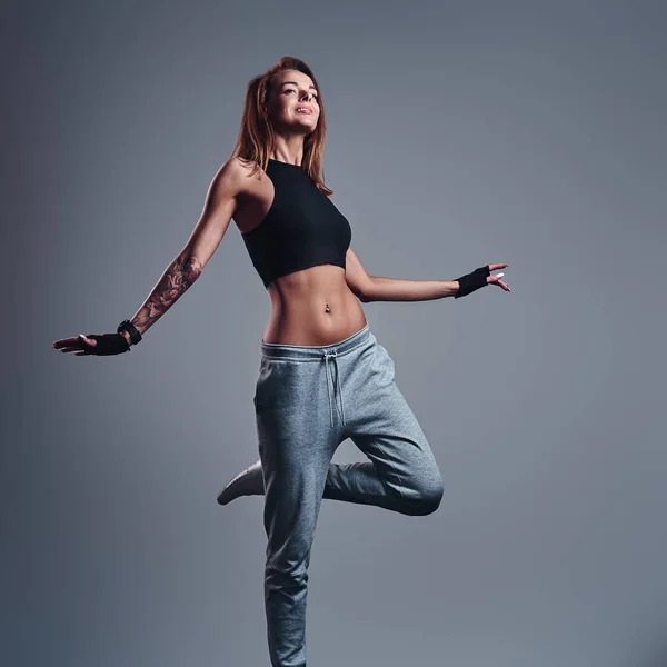 Full-length portrait of a slim fitness girl wearing sportswear posing in a studio. — Stock Photo, Image