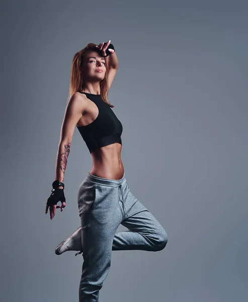 Ganzkörperporträt eines schlanken Fitness-Girls in Sportbekleidung, das in einem Studio posiert. — Stockfoto