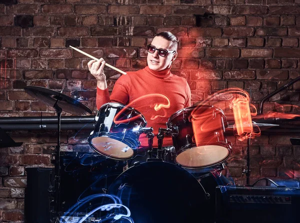 感情的にレンガの壁を背景にドラムのサングラスでスタイリッシュなミュージシャン — ストック写真