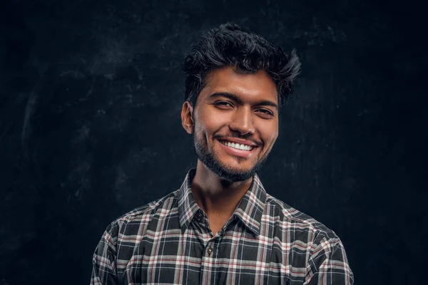 Närbild porträtt av en stilig indiska man som bär en rutig skjorta, leende och tittar på en kamera. — Stockfoto