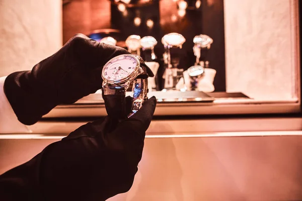 Gros plan des vendeurs mains dans les gants montre la montre exclusive des hommes de la nouvelle collection — Photo