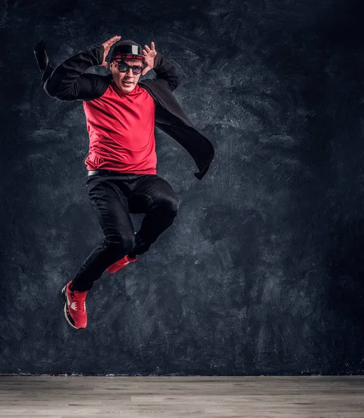 Emotionele stijlvol geklede man uitvoeren van breakdance springen. — Stockfoto