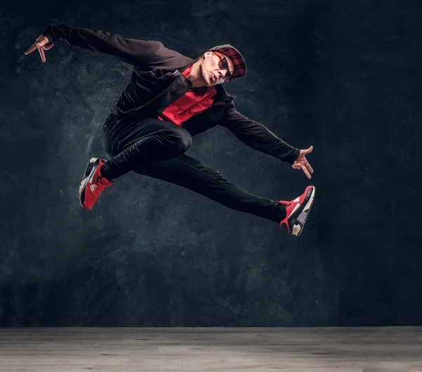 Emocionální stylově oblečený chlap provedení break dance skákání. — Stock fotografie