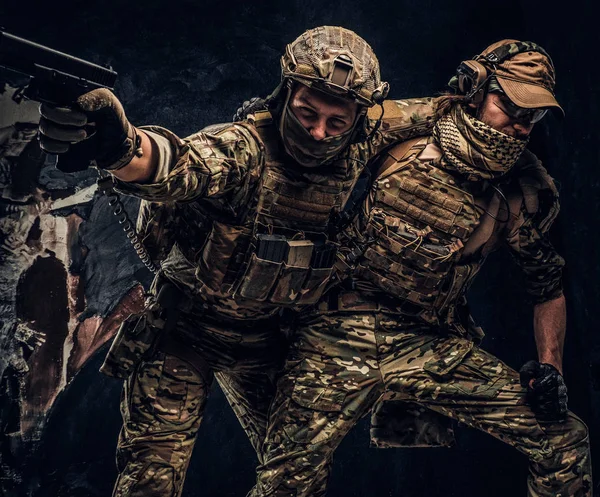 Kampfkonflikte, besondere Mission. der Soldat, der Teamkollegen aus dem Schlachtfeld trägt. Studiofoto vor dunkler Wand — Stockfoto