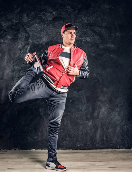 Professionele breakdancer dragen van modieuze kleding, warming-up en stretching zijn benen voor prestaties. — Stockfoto