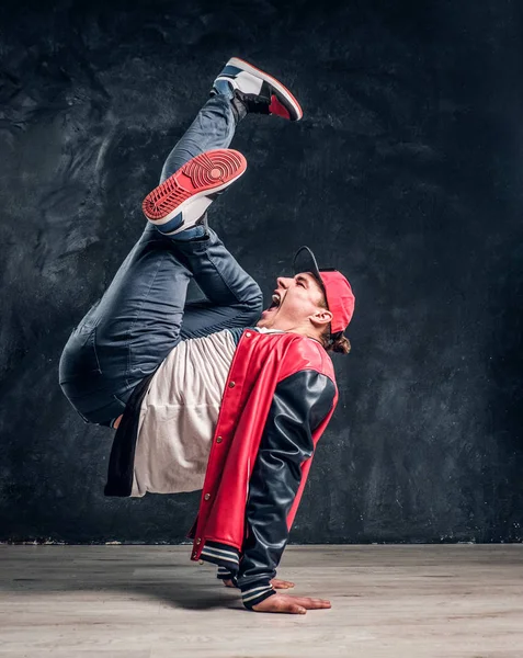 Emotionele stijlvol geklede man uitvoeren van breakdance beweegt op de vloer. — Stockfoto