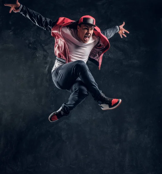 Emocionální stylově oblečený chlap provedení break dance skákání. — Stock fotografie