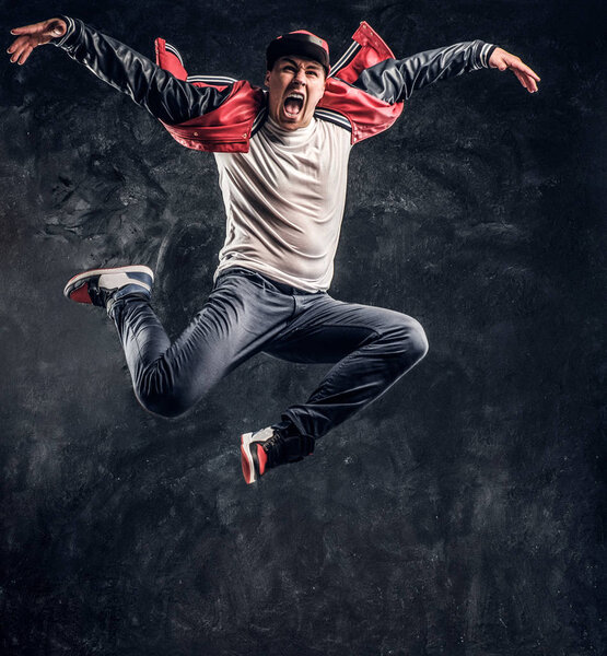 Stylish guy performs breakdance acrobatic elements.