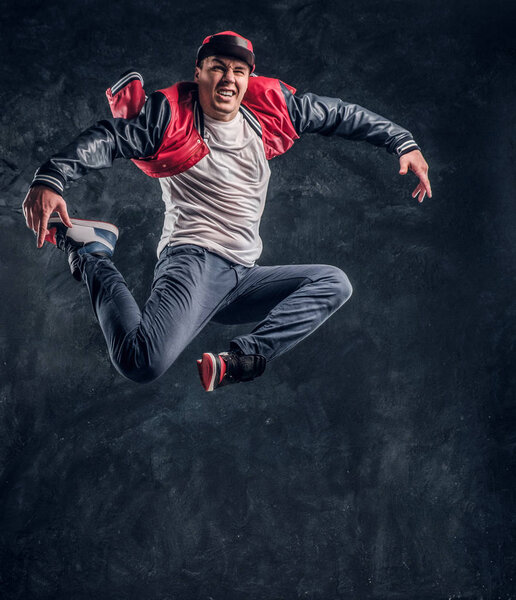 Stylish guy performs breakdance acrobatic elements.