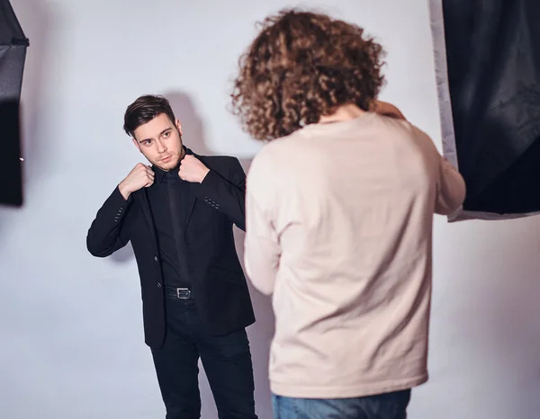 Beginnende fotograaf op een fotoshoot in een studio met een elegant gekleed man — Stockfoto