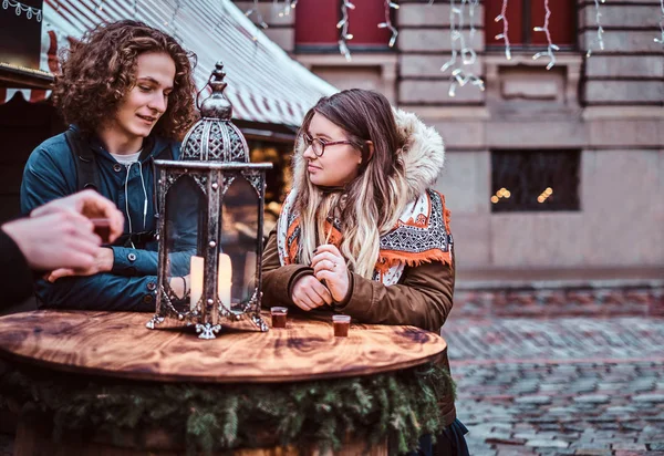 Due ragazzi e una ragazza turisti rilassarsi con bevande sul mercato della piazza della città — Foto Stock