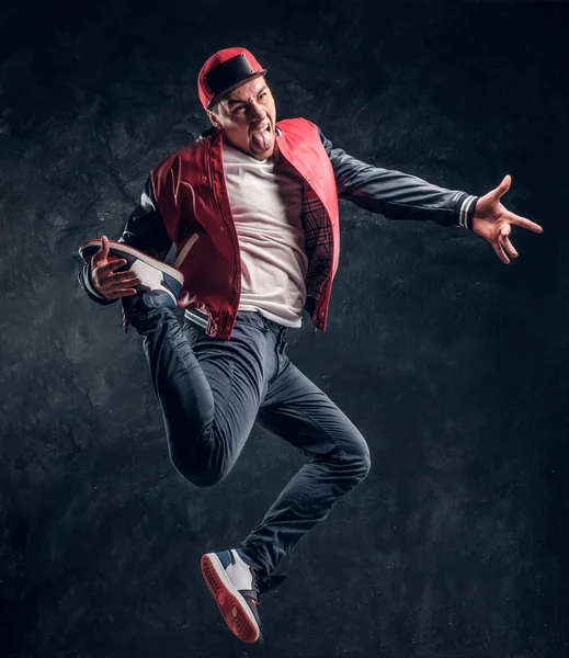 Emocionální stylově oblečený chlap provedení break dance skákání. — Stock fotografie