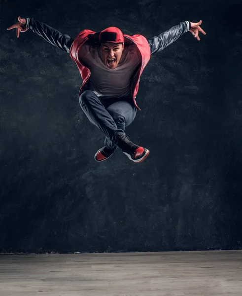 Emotional stylish dressed guy performing break dance jumping. — Stock Photo, Image