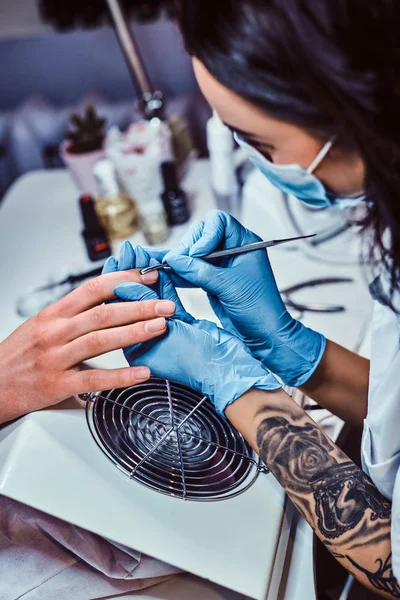 Schoonheidsspecialiste beheersen de procedure trim en verwijderen van de nagelriemen in de schoonheidssalon — Stockfoto