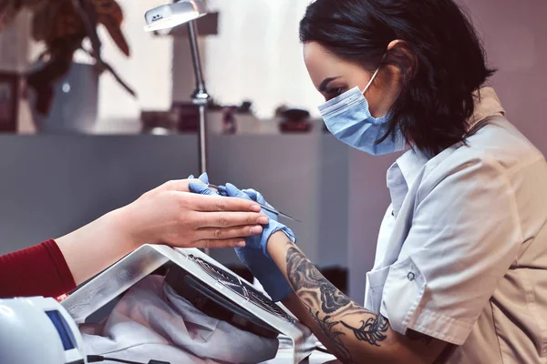 Esthéticienne maîtriser la procédure pour couper et enlever les cuticules dans le salon de beauté — Photo