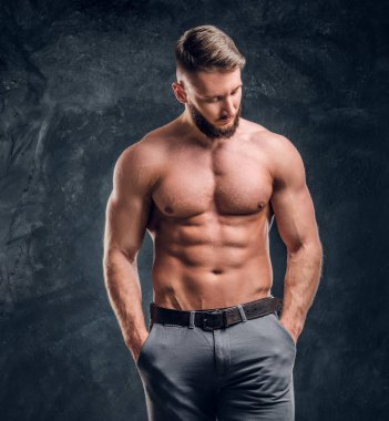 Erkek model bir kamera için poz kas vücut ile. Studio fotoğraf bir karanlık duvar arka plan