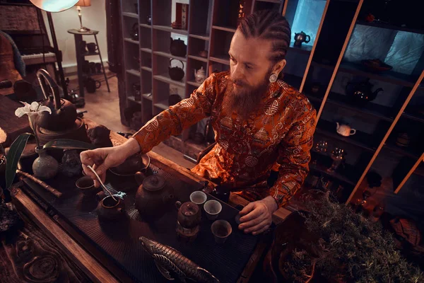 Maître caucasien en kimono faisant du thé naturel dans la pièce sombre avec un intérieur en bois. Tradition, santé, harmonie. Cérémonie du thé chinois — Photo