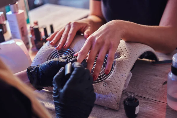 Cuidados com as unhas e manicure. Uma mulher num salão de beleza. Mãos fechadas — Fotografia de Stock