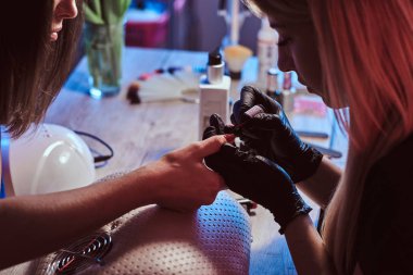 güzel manikürcü tırnak cilası uygulayarak.