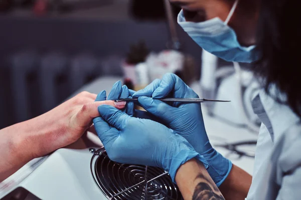 Beautician master the procedure to trim and remove cuticles in the beauty salon — Stock Photo, Image