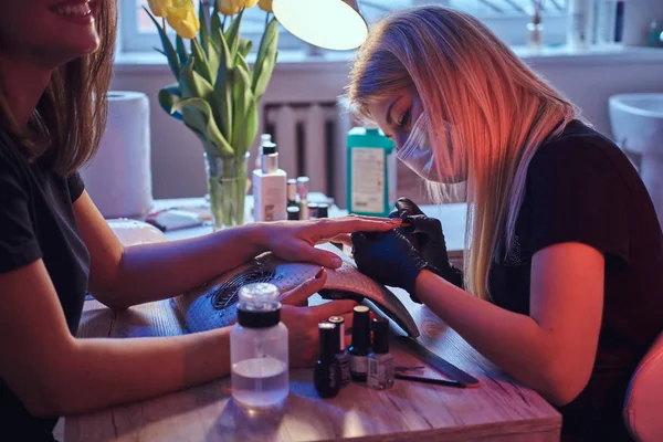 Mistrz manicure stosowanie Polski na paznokcie naturalne klientów w salonie piękności. — Zdjęcie stockowe