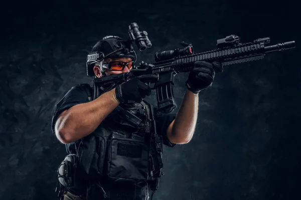 Special forces soldier holding an assault rifle with a laser sight and aims at the target. — Stock Photo, Image