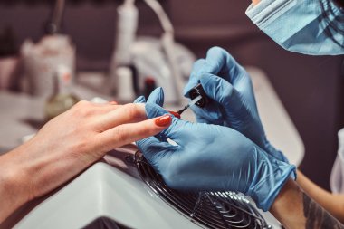 El çekim. Devam manikür prosedürü-renk oje uygulayarak güzellik ustası.