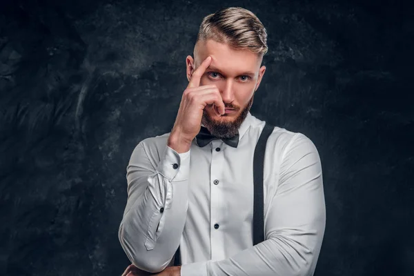 Надійний чоловік думає про щось важливе. Стильно одягнений молодий чоловік у сорочку з краваткою і підтяжки позує рукою на підборідді . — стокове фото