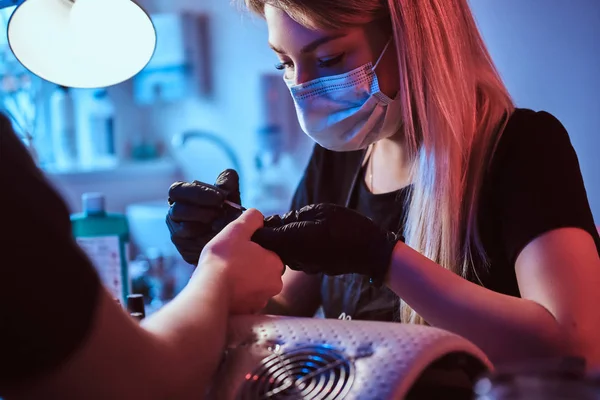 Bonito mestre manicure está trabalhando em clientes unhas . — Fotografia de Stock