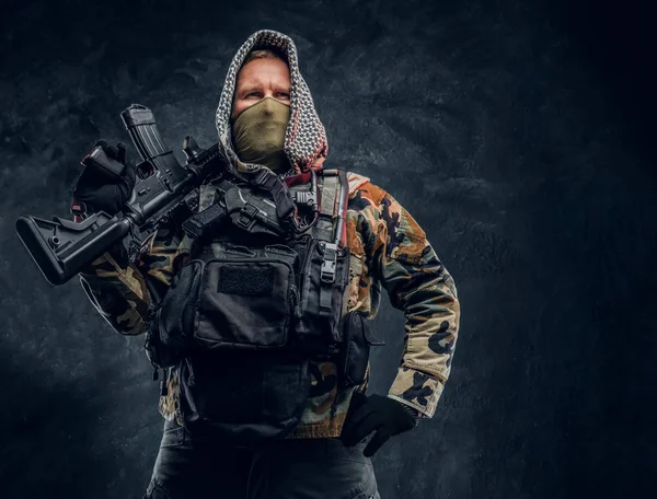 Soldato delle forze speciali in uniforme militare in maschera e cappuccio in posa con un fucile d'assalto . — Foto Stock