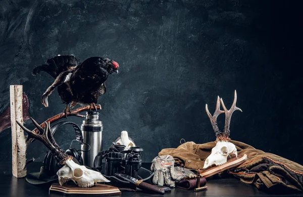 Εξοπλισμός κυνηγών και τρόφς σε ένα τραπέζι. Φωτογραφία στούντιο σε φόντο σκούρο τοίχο — Φωτογραφία Αρχείου