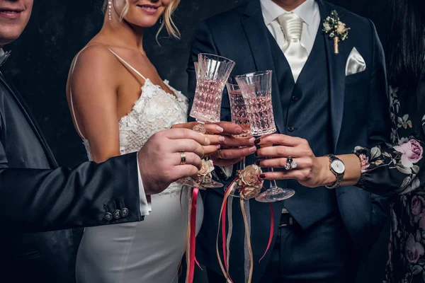 Primer plano de la novia y el novio tintineo copas de champán en una fiesta de boda . —  Fotos de Stock