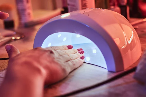 Klient w manicure salon dryes paznokcie żelowe w świetle UV — Zdjęcie stockowe