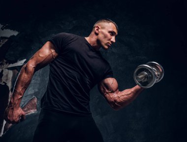 Karanlık bir arka planda dumbbell ile kas adam