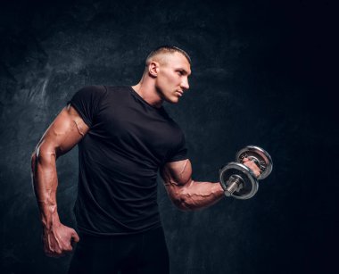 Karanlık bir arka planda dumbbell ile kas adam