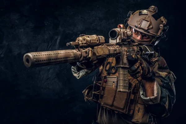 Unidade de elite, soldado das forças especiais em uniforme de camuflagem segurando um rifle de assalto com mira de laser e aponta para o alvo . — Fotografia de Stock