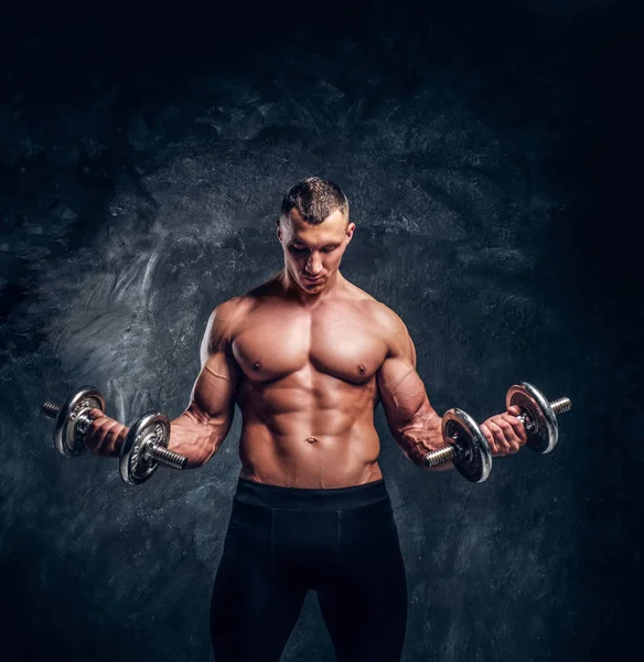 Sterke aantrekkelijke bodybuilder maakt oefeningen met halters — Stockfoto