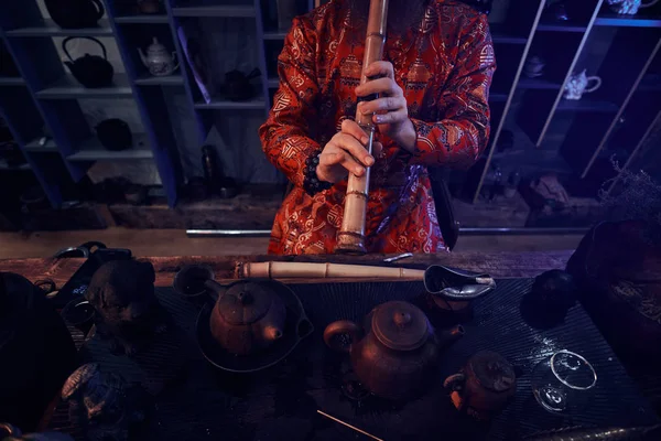 Tradycja, zdrowia, harmonii. Chińskich ceremonii parzenia herbaty. Mistrz herbaty w kimono wykonuje się w ciemnym pomieszczeniu w drewnie, grając na bambusowy flet — Zdjęcie stockowe