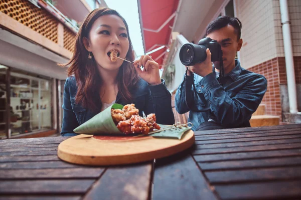 Genç Asya çift zevk Çin gıda ve fotoğraf çekim