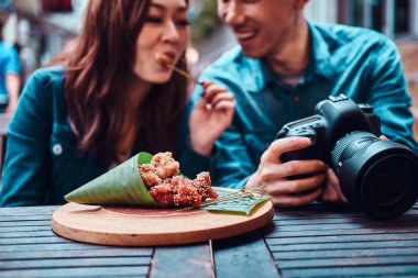 Asya çift Çin gıda zevk ve resimleri izliyor