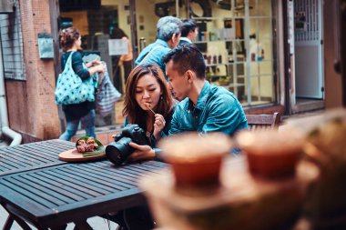 Asya çift Çin gıda zevk ve resimleri izliyor