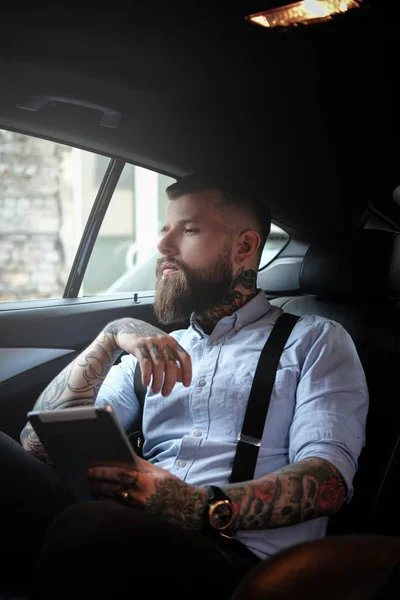 Retrato de homem barbudo com tatuagens no carro — Fotografia de Stock