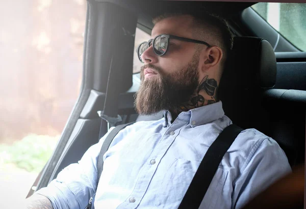 車の中で tattoes を持つひげを生やした男の肖像 — ストック写真