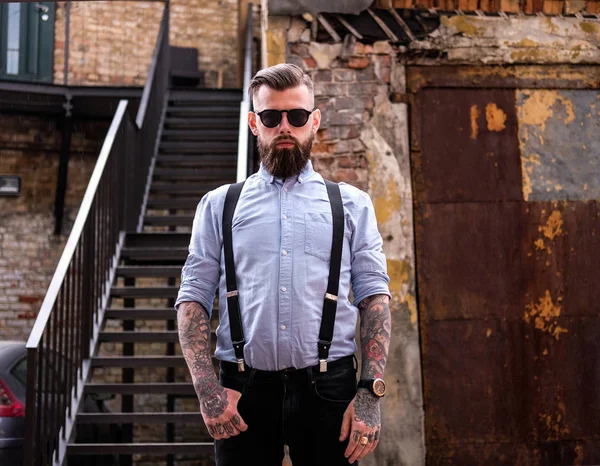 A szakállas férfi portréja tattooes a karjaiba — Stock Fotó
